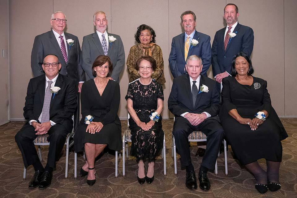 A group of men and women pose for a photo.