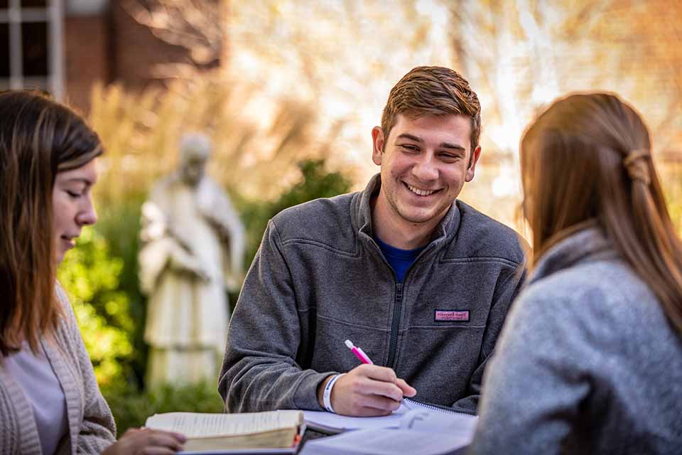 Male student with pen at table