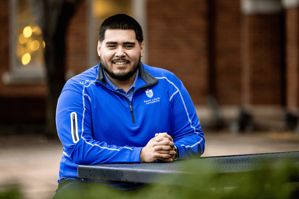 Gael Cosgaya sits at a table outside on campus.