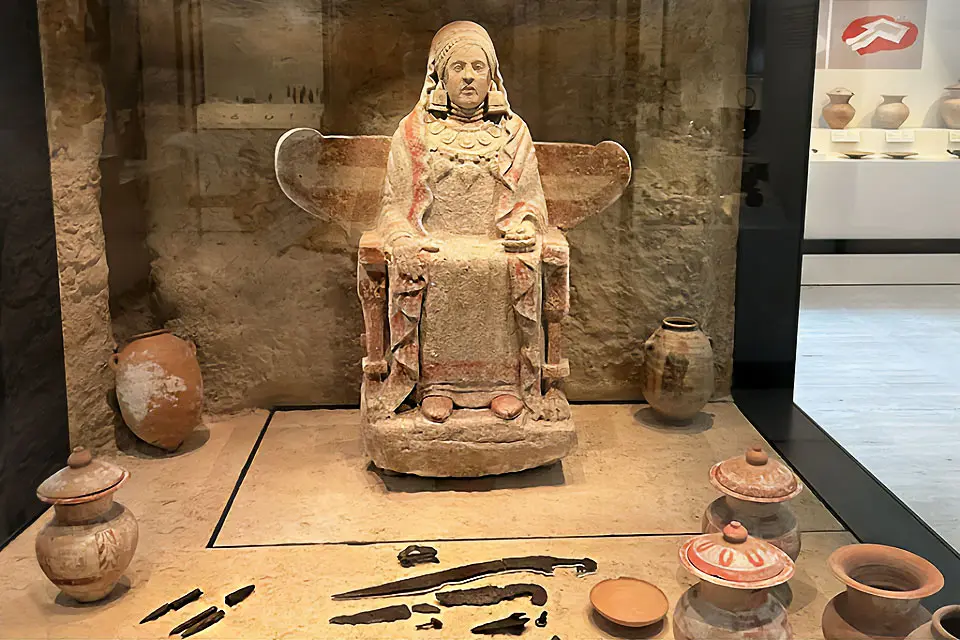 Image of the National Archaeological Museum, with marble statues and busts in a hall bordered by arch ways.