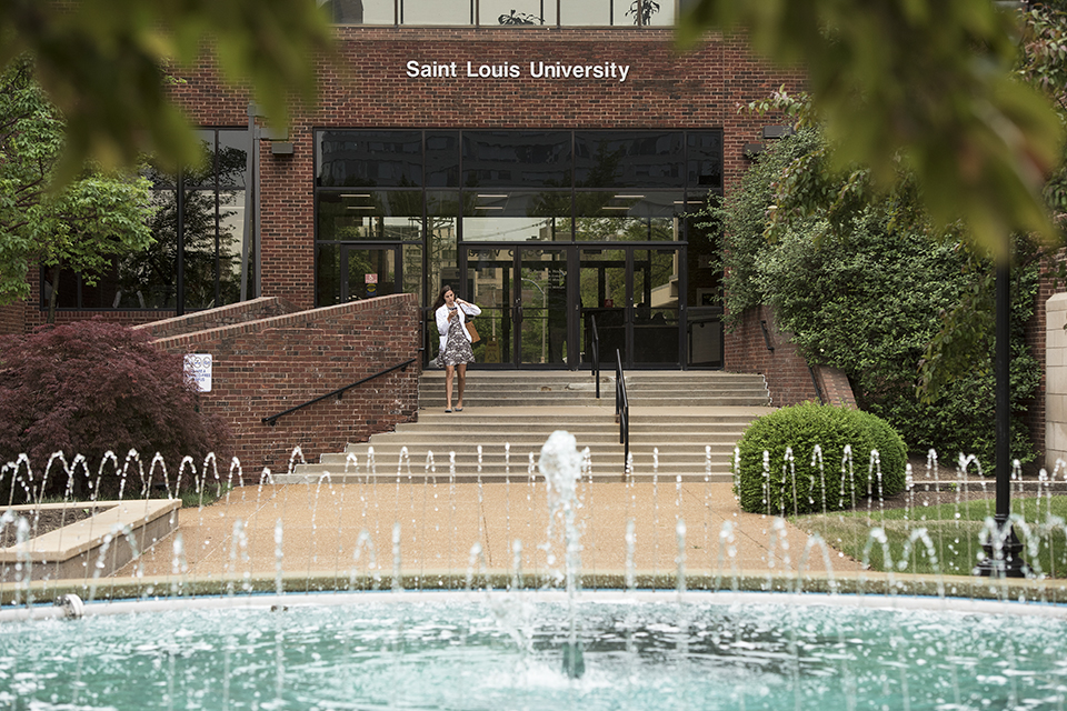 A student walks out of the School of Medicine building