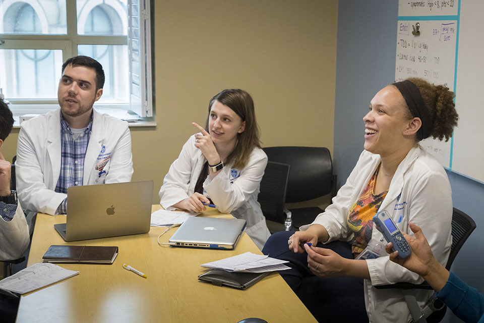 Medical students around a table in a conference room