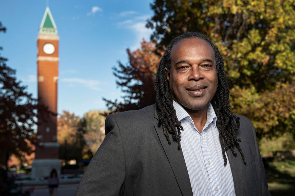 A photo of the late Dr. Jonathan C. Smith standing in front of SLU's clock tower