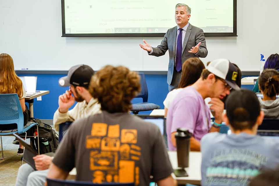 Provost Mike Lewis standing in front of a classroom teaching