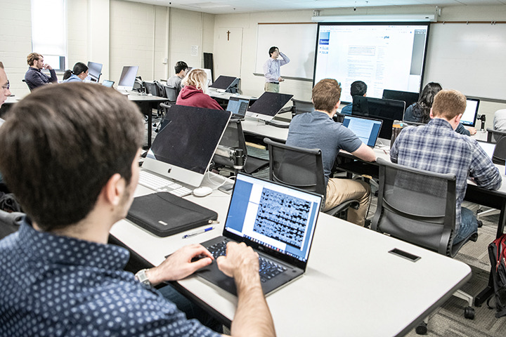 Students with laptops in computer science classroom